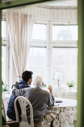 Rückansicht eines Hausmeisters mit einem älteren Mann im Pflegeheim - MASF03355