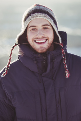 Portrait of happy young man standing outdoors during winter stock photo