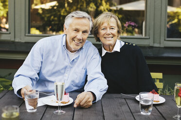 Porträt eines glücklichen älteren Paares beim Dessert in einem Restaurant im Freien - MASF03405