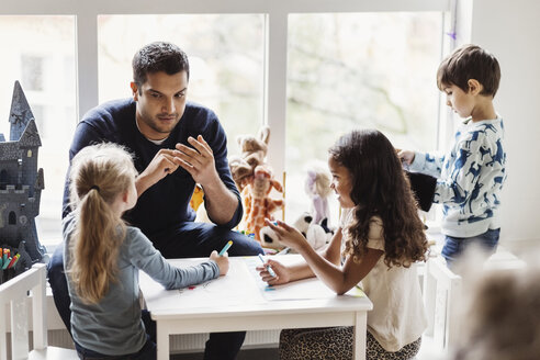 Male teacher with students in preschool - MASF03445