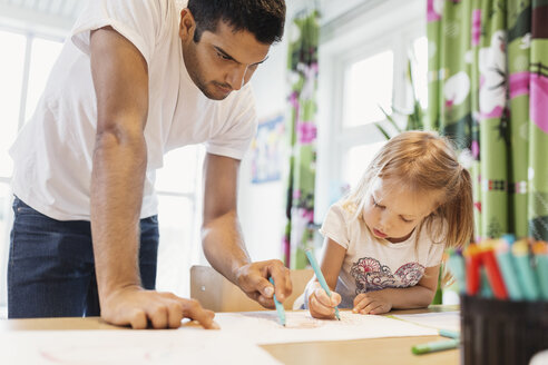 Männliche Kinder helfen einem kleinen Mädchen beim Zeichnen im Klassenzimmer - MASF03446