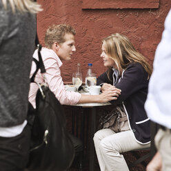 Mid adult couple at sidewalk cafe talking - MASF03453