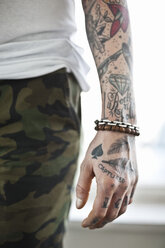 Midsection of a man with tattooed hand - MASF03460