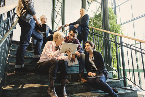 Multi-ethnic business people discussing on stairway in creative office - MASF03465