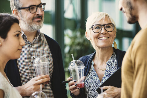 Multi-ethnic business people discussing while having refreshments in creative office - MASF03470