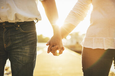 Midsection of loving senior couple holding hands on pier - MASF03489