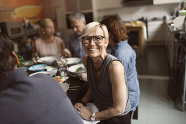 Portrait of cheerful mature woman sitting with friends at table - MASF03498