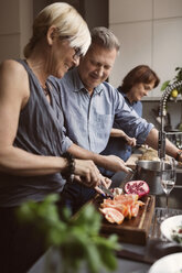 Happy friends preparing food in kitchen - MASF03584