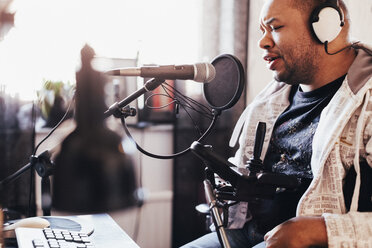 Behinderter männlicher Sänger bei der Aufnahme von Musik im Studio - MASF03608