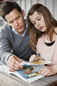 Vater hilft Tochter beim Verstehen, während er ein Buch liest - MASF03612