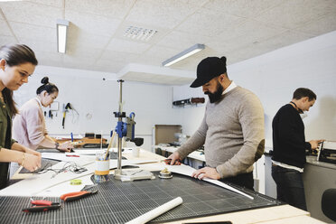 Engineers working on desk at workshop in creative office - MASF03656