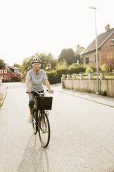 Front view of senior woman cycling on road against clear sky - MASF03659
