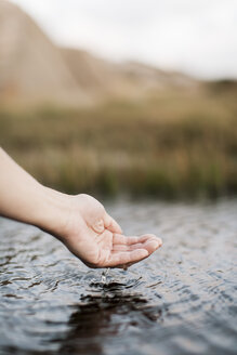 Ausgeschnittenes Bild der Hand einer Frau über dem Fluss - MASF03662