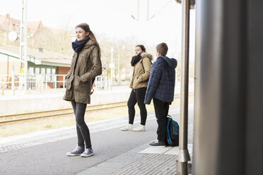 Junge Frau mit Freunden wartet am Bahnhof auf einen Zug - MASF03673