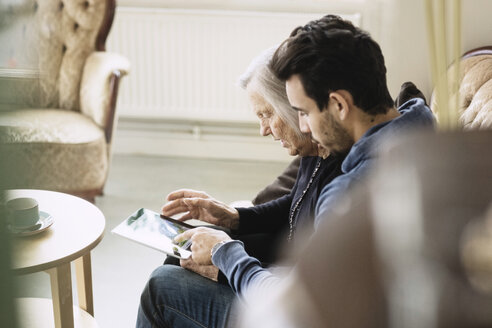 Pflegerin und Seniorin nutzen digitales Tablet im Pflegeheim - MASF03689