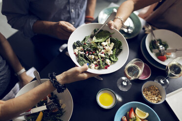 Ausgeschnittenes Bild von Freunden mit Salatschüssel am Tisch - MASF03734