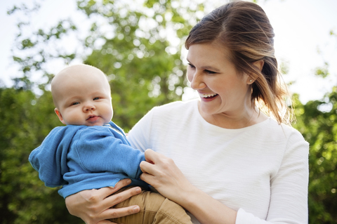 Fröhliche Frau mit einem kleinen Jungen im Park, lizenzfreies Stockfoto