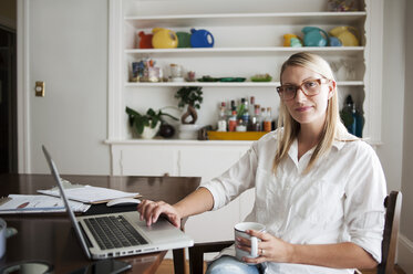 Portrait of confident woman using laptop at home - CAVF38134