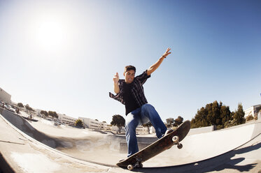 Niedriger Blickwinkel von Mann Skateboarden im Park gegen klaren Himmel an einem sonnigen Tag - CAVF38181