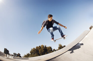 Niedriger Blickwinkel von Mann Durchführung Stunt in Skateboard-Park gegen klaren blauen Himmel - CAVF38182