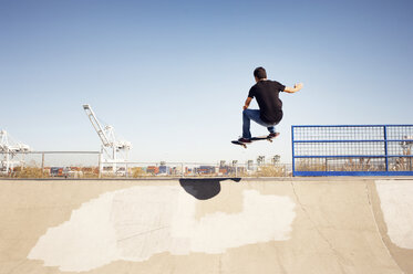 Niedriger Blickwinkel auf einen Mann, der einen Stunt in einem Skateboardpark ausführt - CAVF38184