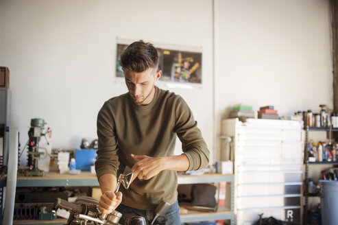 Mann arbeitet in der Garage an einem Motorrad - CAVF38207