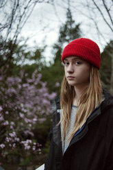 Portrait of teenage girl standing on field against sky at dusk - CAVF38209