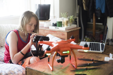 Junge untersucht die Fernsteuerung einer Drohne zu Hause - CAVF38231