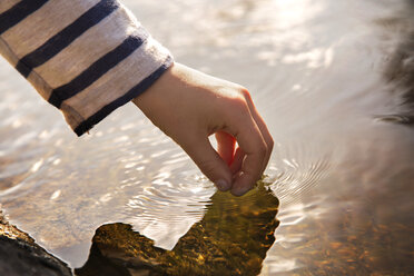 Ausgeschnittenes Bild einer Hand, die Wasser berührt - CAVF38238