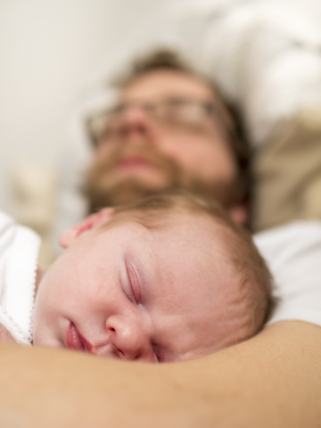 Father and newborn girl sleeping stock photo