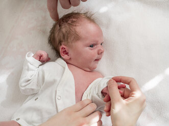 Neugeborenes Mädchen beim Anziehen, Hand von Vater und Mutter - LAF01997