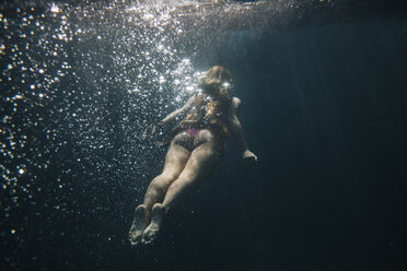 Rückansicht einer unter Wasser schwimmenden Frau - CAVF38263