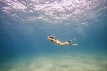 Full length of woman swimming undersea - CAVF38271