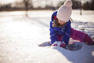 Girl playing with snow on sunny day - CAVF38288