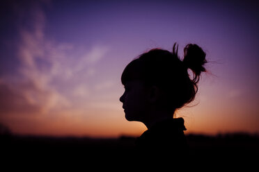 Silhouette Mädchen gegen dramatischen Himmel bei Sonnenuntergang - CAVF38293