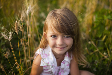 Portrait of happy girl sitting on farm - CAVF38297