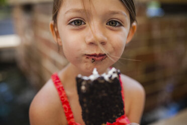 Porträt eines glücklichen Mädchens, das ein Schokoladen-Eis isst - CAVF38328
