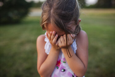 Close-up of girl covering face while crying outdoors - CAVF38355