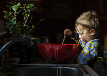 Junge spielt mit Essen in der Küche - CAVF38365