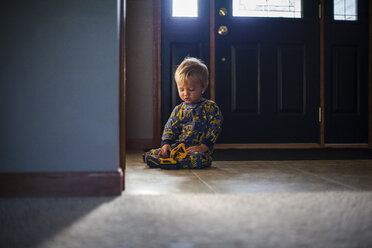 Cute boy playing with toy on floor at home - CAVF38386