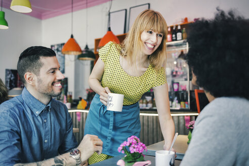 Frau serviert Kaffee an Kunden in einem Café - MASF03749