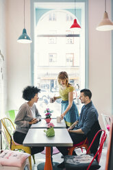 Kellnerin serviert Kaffee an Kunden in einem Café - MASF03751