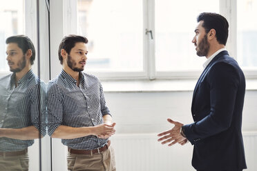 Young businessman discussing with male colleague in office - MASF03797