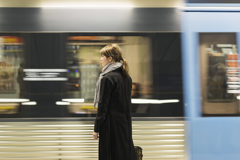 Junge weibliche Passagierin steht am Bahnsteig - MASF03806