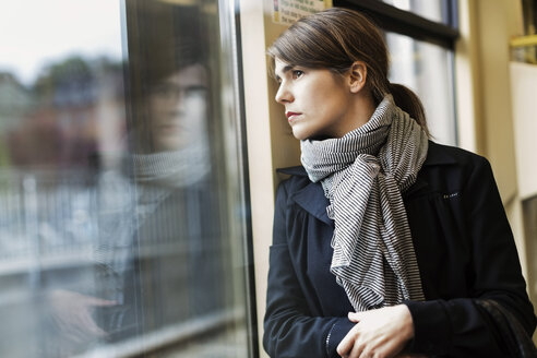 Nachdenkliche junge Frau schaut aus dem Straßenbahnfenster - MASF03809