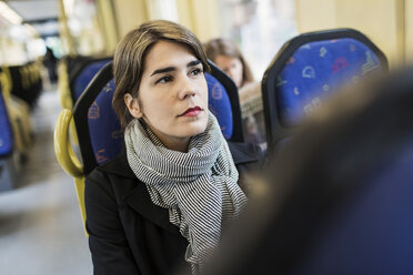 Nachdenkliche junge Frau, die in der Straßenbahn wegschaut - MASF03810