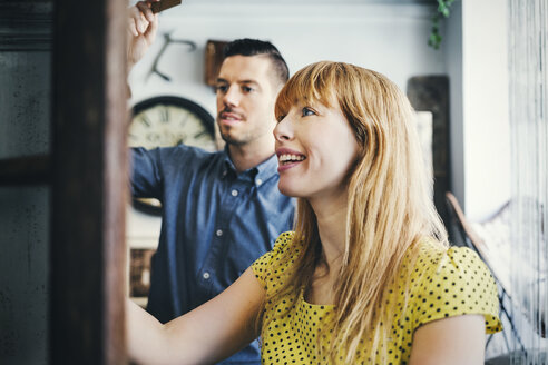 Smiling mid adult woman standing with colleague in store - MASF03871