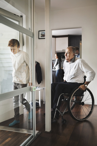 Sohn und Vater betreten den Rollstuhllift zu Hause, lizenzfreies Stockfoto