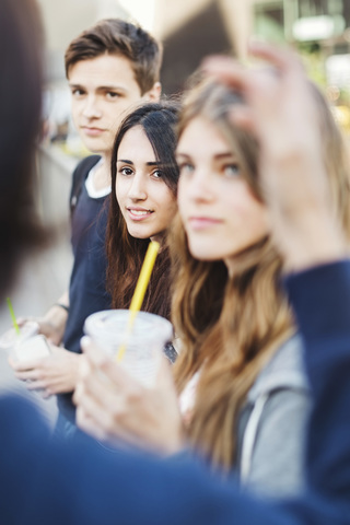 Teenagers looking at friend outdoors stock photo