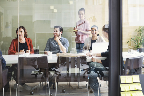 Lächelnde Geschäftsleute am Tisch im Konferenzraum, lizenzfreies Stockfoto